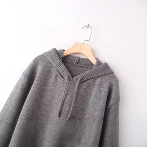 Relaxed fit mid-grey knitted hoodie with matching drawstrings on a wooden hanger