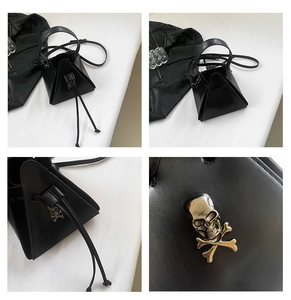 Detail of black punk pyramid bag with metal skull ornament and smooth PU leather