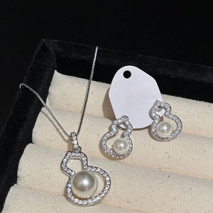 Detail of zircon and pearl gourd jewelry set showcased in a black velvet gift box