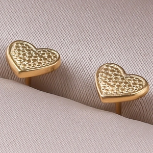 Detailed macro shot of vintage heart-shaped stud earrings with unique textured finish