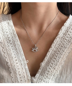 Detail of silver rocking horse pendant with embedded crystals on a delicate chain