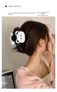 Close-up of a cute plush panda hair claw clip worn on a bun for a sweet hairstyle