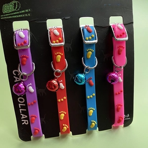 Detail of four colorful silicone pet collars with bell and paw patterns on display card