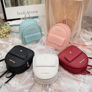 Detail showing five colors of lychee grain PU leather mini bags with golden zippers