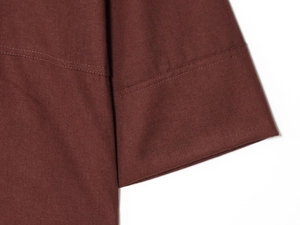 Detail view of double stitching on dark brown shirt sleeve hem with high-quality seam craft