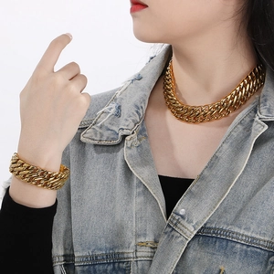 Close-up of chunky gold-plated stainless steel Cuban link chain necklace and bracelet set
