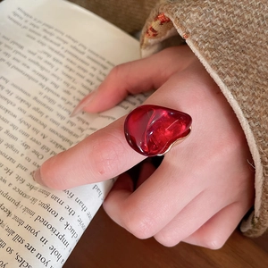 Détail de la bague en résine rouge transparente en forme de cœur et base dorée
