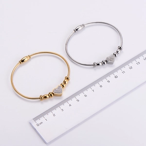 Detail of twisted cable heart bracelet in gold and silver finish with magnetic clasp