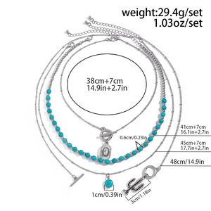 Detail view of bohemian turquoise bead necklaces with silver cactus and coin charms