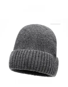 Close-up of dark gray knit beanie featuring a thick ribbed texture and brown leather patch
