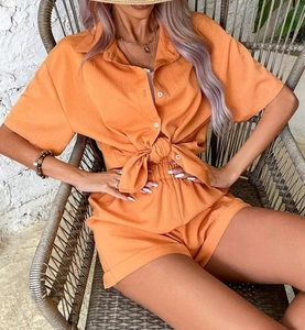 Detail of orange summer set featuring a short-sleeve shirt and high-waisted shorts