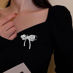 Elegant bow-shaped brooch featuring micro-set cubic zirconia and lustrous white pearls