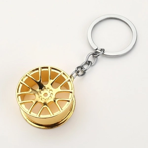 Close-up of golden multi-spoke wheel hub keychain with polished silver metal ring