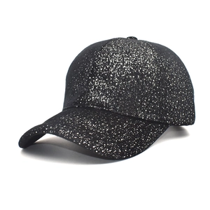 Detailed view of women's black glitter baseball cap with silver sequins and curved brim