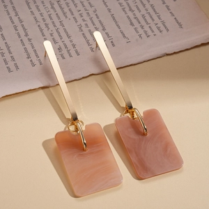 Detail of long geometric acetate earrings with pink marble resin and golden metal bars
