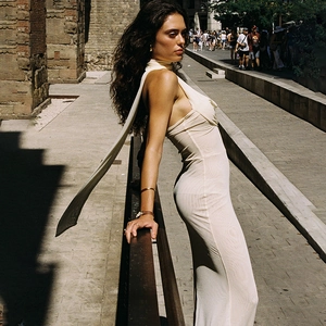 Détail d'une robe longue en maille beige sans manches avec dos nu et liens à nouer