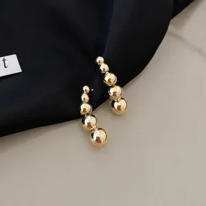 Minimalist gold ball ear climbers featuring five gradient size beads in a sleek arc shape