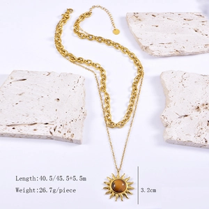 Détail du collier soleil doré double couche avec pierre oeil de tigre sur socle