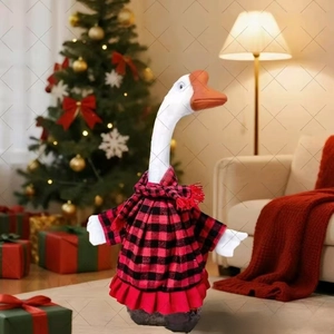 Detail of white garden goose statue wearing festive red and black buffalo plaid Christmas outfit