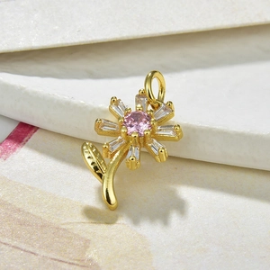 Close-up of golden sunflower pendant with pink center and clear gemstone petals
