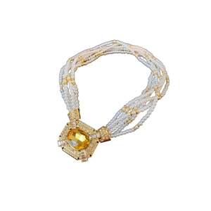 Elegante collana di perle multifilo con grande ciondolo d'oro e gemma gialla