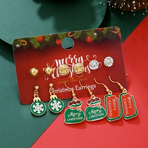 Close-up of 6 pairs of Christmas earrings featuring snowflakes, elk, and trees on a red card