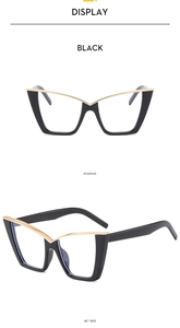 Detail view of black cat-eye glasses frame with gold V-shaped metal accents and side hinge