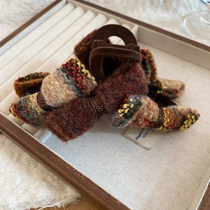 Detail of a vintage knitted bow hair claw clip in a velvet tray for autumn and winter