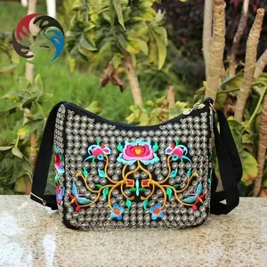 Close-up of ethnic canvas crossbody bag with intricate golden embroidery and pink lotus detail