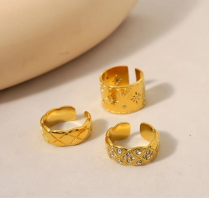 Dettaglio del set di anelli dorati con stella incastonata di diamanti e motivi trapuntati