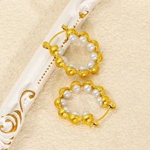 Macro view of 18k gold plated wave edge hoop earrings with inset white round pearls