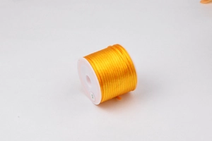 Dettaglio del cordino in nylon giallo da 1,5 mm su rocchetto bianco per fai-da-te