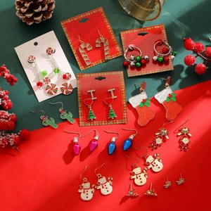 Flat lay of festive Christmas earrings including candy canes, trees, and snowmen designs