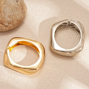 Bracciali larghi geometrici irregolari in oro e argento con consistenza metallo liquido