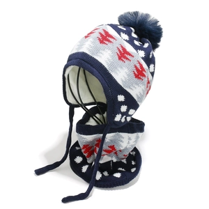 Close-up of knit winter hat and scarf set with Nordic patterns and large pom-pom