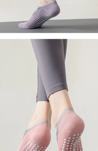 Detail der rutschfesten Silikonnoppen an lila und rosa Yoga-Socken für Pilates