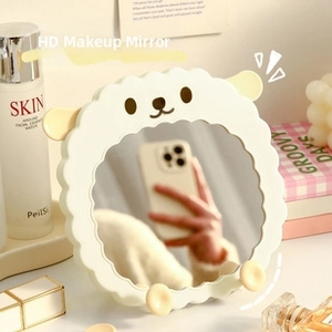 Close-up of cute alpaca shaped makeup mirror with wavy edges in cream white for vanity