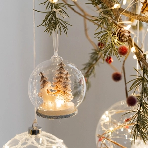 Luminous Christmas glass ball with reindeer and snowy tree scene, warm holiday decor
