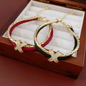 Detailed shot of gold-plated double-layer braided leather bracelets with zircon X-link detail