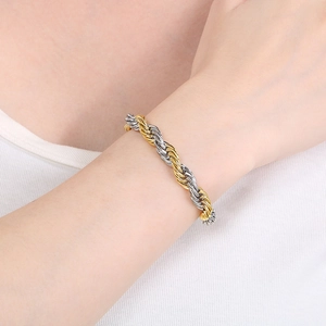 Close-up of gold and silver bicolor twisted rope chain bracelet worn on a wrist