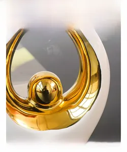 Macro detail of abstract ceramic ornament with polished gold electroplated metal sphere