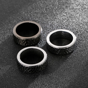 Macro detail of men's titanium steel rings featuring vintage hammered texture finish