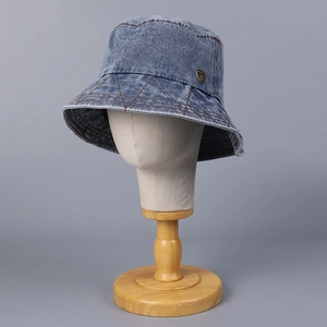 Classic washed blue denim bucket hat with diamond stitching and golden shield emblem