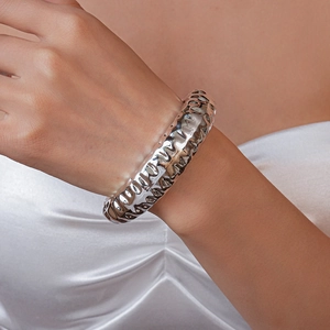 Detailed view of silver thick bangle with hammered lava texture on a female wrist