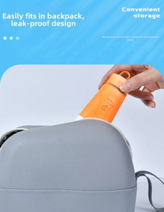 Close-up of orange silicone travel bottle being placed into a grey leather storage bag