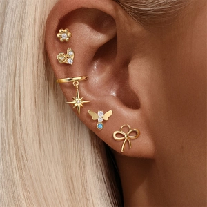 Detailed macro view of gold ear cuff set with opal and marquise-cut zircon stones