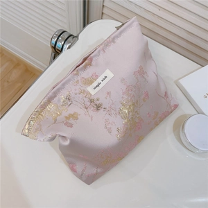 Détail d'une trousse à maquillage en jacquard rose avec motif floral et étiquette Simple Wish