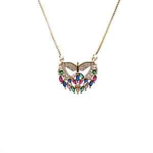 Close-up of golden angel heart pendant with vibrant colorful zircon stones inlay