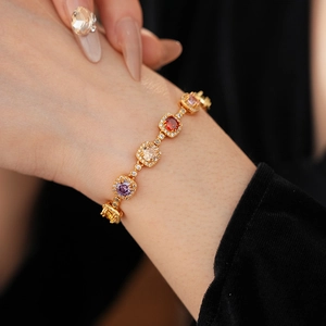 Close-up of vintage gold bracelet with colorful square gemstones and pavé zircon details