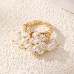 Detailed macro view of a vintage gold adjustable ring with a cluster of white pearls